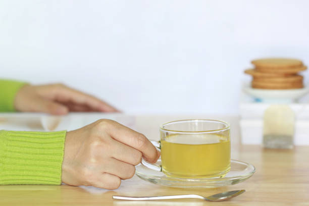 istock Female hands holding tea cup and open read  on the table 821572638