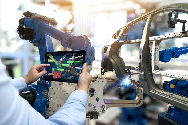 istock Industry 4.0 concept . Man hand holding tablet with performance check screen software and automate wireless Robot arm in automobile smart factory background. 821575316