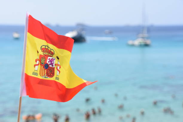 flagge von spanien am strand von ibiza - spain flag built structure cloud stock-fotos und bilder