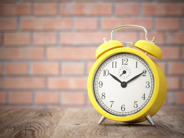 istock 3D rendering yellow alarm clock on wood table 821588162