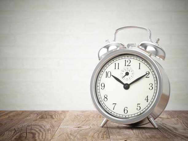 istock 3D rendering metal alarm clock on wood table 821588508