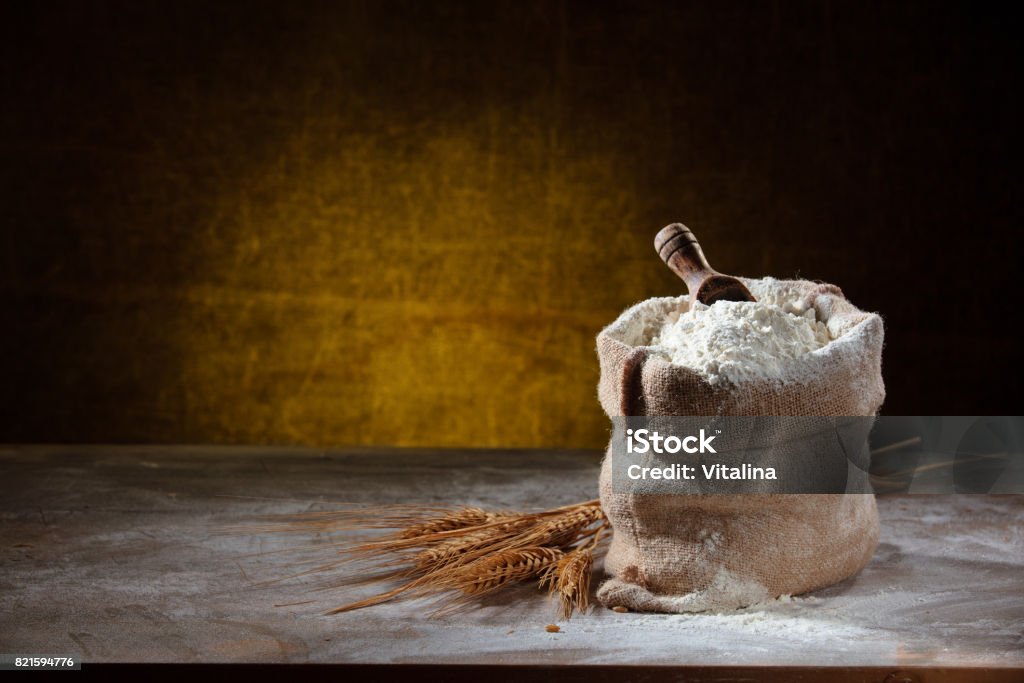 Flour and eggs. Closeup shot of flour in sack on rustic wooden table. Flour Stock Photo