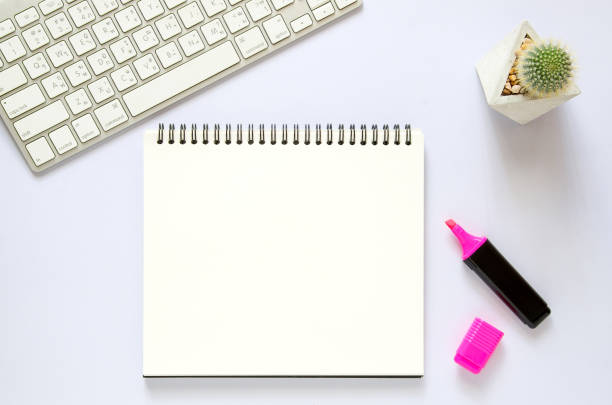 istock Office workplace concept. Computer keyboard with blank notebook, cactus, marker color pen on white desk. Top view with copy space, flat lay. 821601360