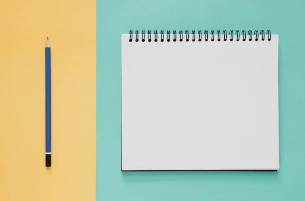 Office workplace minimal concept. Blank notebook, pencil on yellow and green turquoise background. Top view with copy space, flat lay. Pastel color filter.
