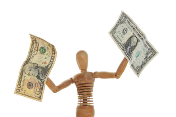istock An artist's mannequin holding american dollars in each hand. 821601794