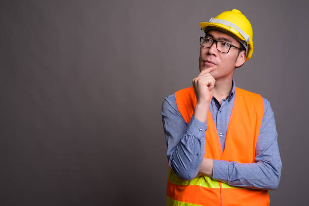 istock Studio shot of young Asian man construction worker against gray background 821604726