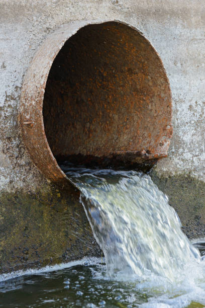 istock Dirty water flows out of a large rusty metal pipe 821605544