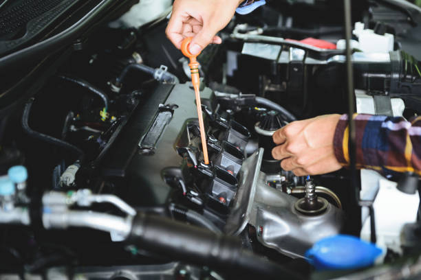 istock Close up hands checking lube oil level of car engine from deep-stick for service and maintenance concept. 821618530