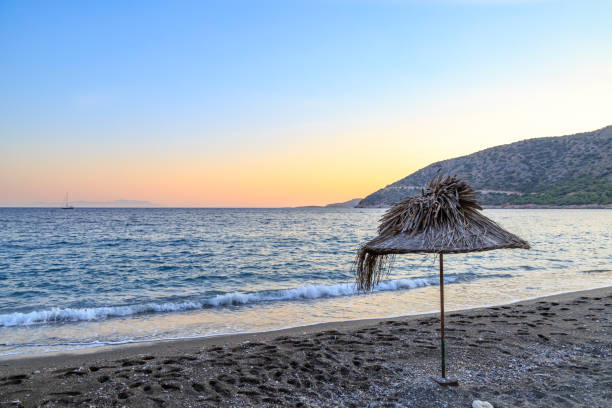 istock Straw umbrella on the beach during sunset 821621430