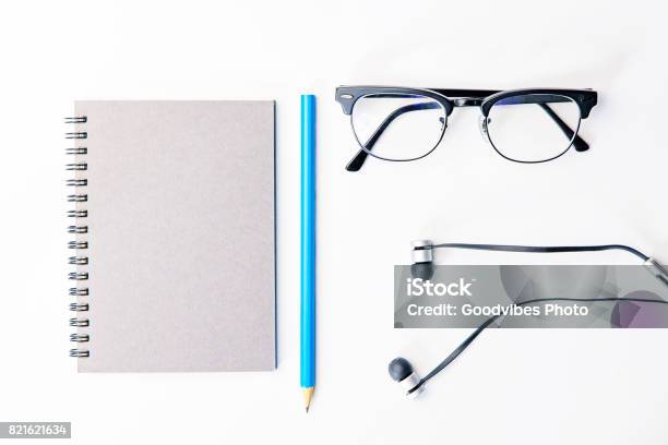 Top View Of Business Working Place With Notepadmodern Glassesearphone On White Tableflatlay Concept Stock Photo - Download Image Now