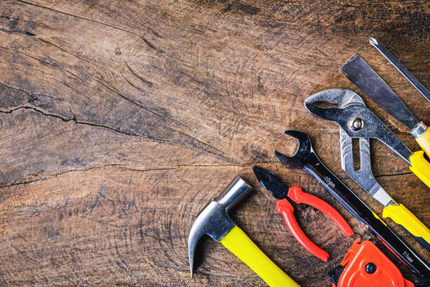 istock Top view of Working tools,wrench,hammer,screwdriver,plier,electric drill,tape measure,machinist square on wooden rustic background. flat lay. 821624736