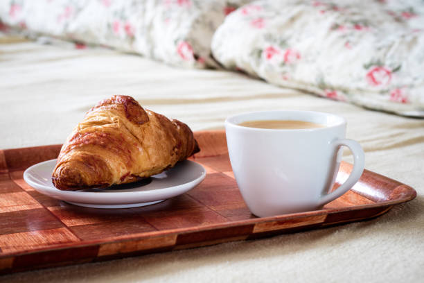istock Tasty breakfast to bed. Croissant with coffee. White background. 821634924