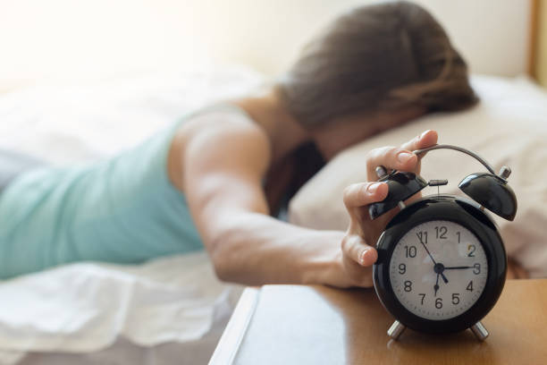 istock Sleepy woman trying kill alarm clock 821634962