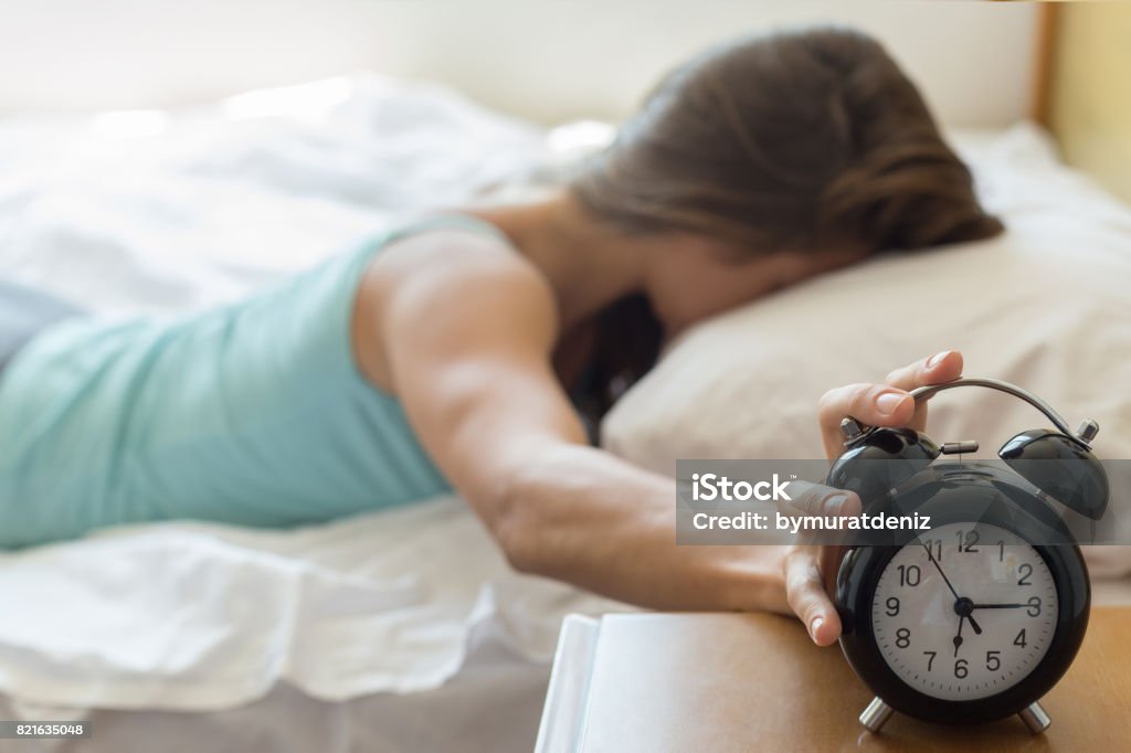 Wake up of a girl stopping alarm clock Alarm Clock Stock Photo