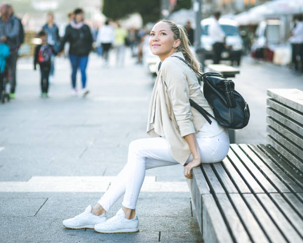 istock Young woman with backpack walking on the european streets 821639936