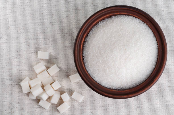 istock granulated sugar in bowl and refined. Closeup top view 821659218