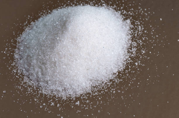 istock Heap of white granulated sugar on gray surface. Close-up 821662080