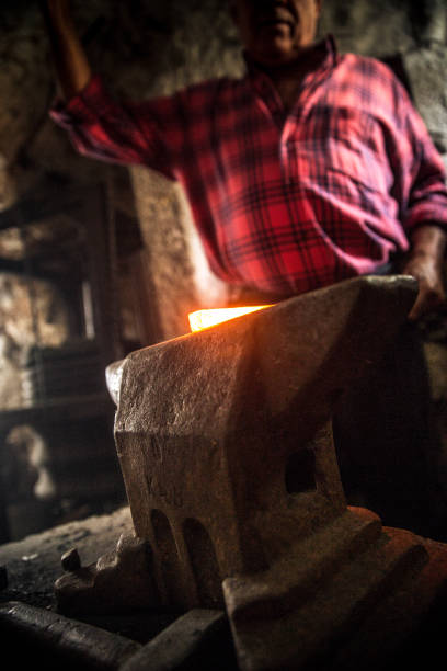 istock Senior Blacksmith Man Forging an Iron Craft on Anvil 821662952