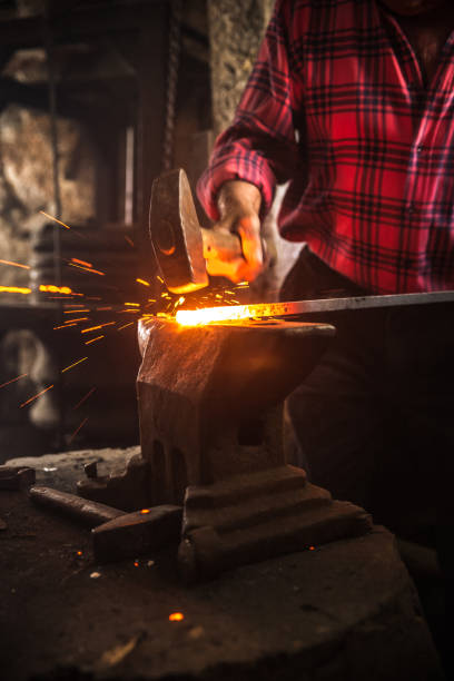 istock Senior Blacksmith Man Forging an Iron Craft on Anvil 821662956
