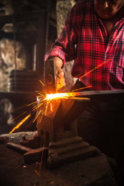 istock Senior Blacksmith Man Forging an Iron Craft on Anvil 821662958