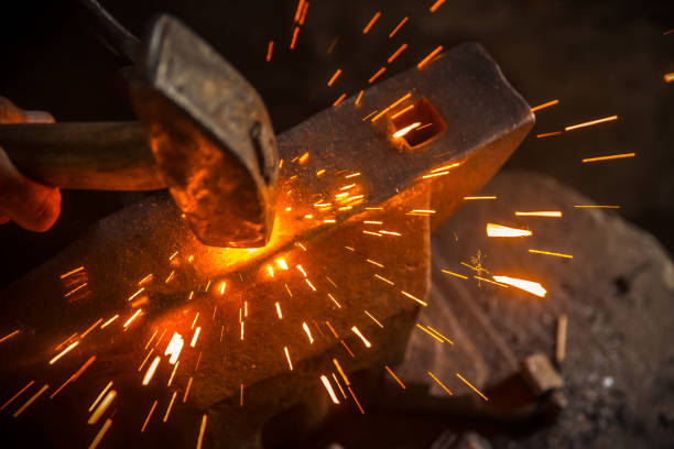 A Hammer Beat Causes Sparks A Hammer Beat Causes Sparks blacksmith shop photos stock pictures, royalty-free photos & images