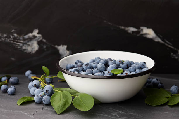 Fresh blueberries bowl on black stone countertop
