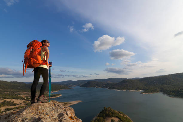 istock Female hiker climbing to mountain peak 821669788