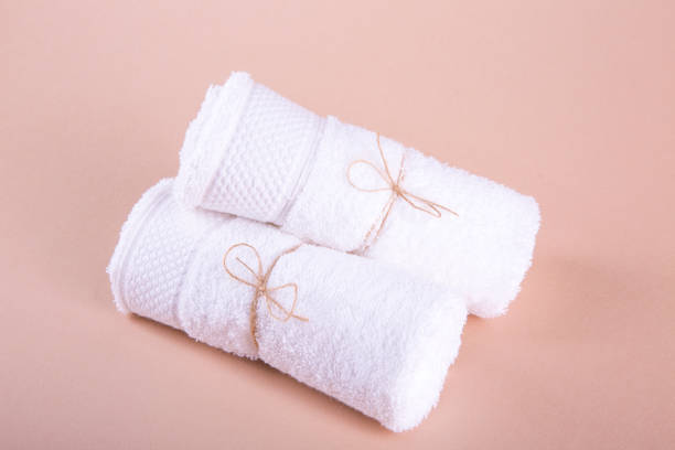 istock Two white canvas rolls rolled up. Pink background. Still life. 821672192