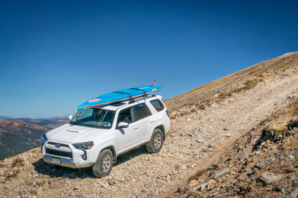 Toyota 4Runner SUV with paddleboard Leadville, Co: Toyota 4Runner SUV (2016 Trail edition) with a paddleboard descending from the Mosquito Pass on a rocky jeep trail in Colorado's Rocky Mountains leadville stock pictures, royalty-free photos & images