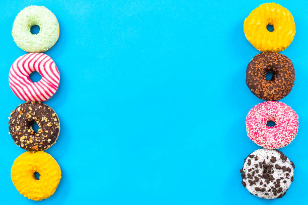 istock Colorful donuts border background, top view flat lay 821676104