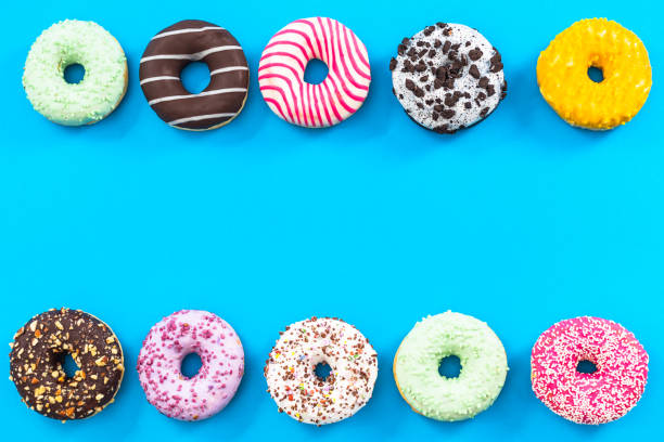 istock Colorful donuts border background, top view flat lay 821676118