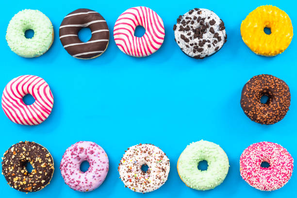 istock Colorful donuts border background, top view flat lay 821676212