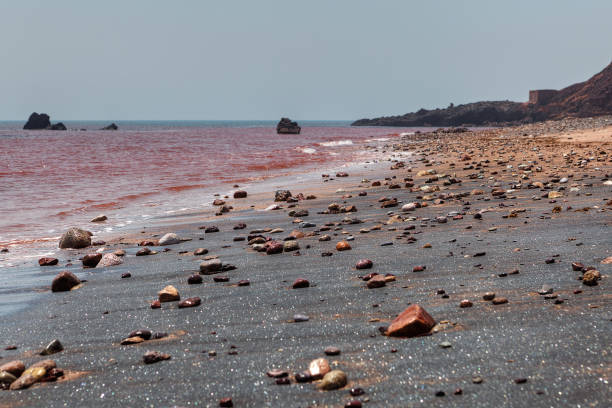 Beach with silver sand and red sea water on Hormuz Island, Hormozgan Province, Iran.