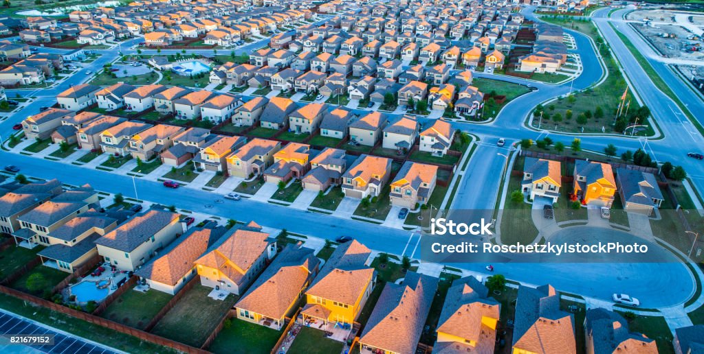 Late Dusk Sunset on Modern Suburban Neighborhood Community North Austin Texas The Suburbs Aerial Drone View above Modern Development Suburbia , Rows after Rows , Thousands of Homes and Rooftops , Afternoon Sunset on Modern Suburban Neighborhood Community North Austin Texas The Suburbs Urban Sprawl Stock Photo