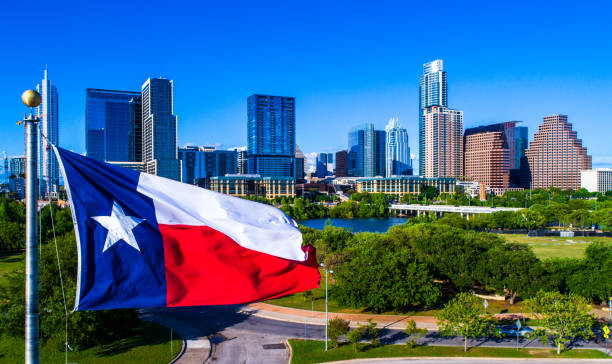 Perfect Texas flag flying in front of Austin Texas downtown skyline cityscape sunny perfect day Aerial drone view Austin Texas Perfect Texas flag flying in front of Austin Texas downtown skyline cityscape sunny perfect day austin texas photos stock pictures, royalty-free photos & images