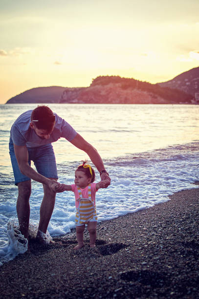 istock Father with baby first steps on the beach 821681482