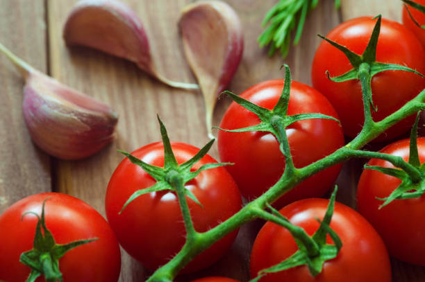 Ripe tomatoes on dark wooden background