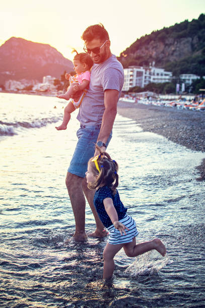 istock Happy young family having fun running on beach at sunset 821682000