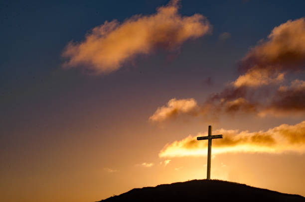 istock Cross on hilltop setting sun behind the crucifix 821684522