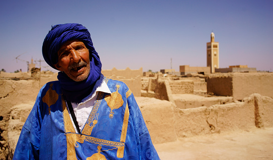 Elford, Morocco - April 28, 2016: Moroccan mature man beard wearing scarves and traditional clothing, the elderly in order to visit visitors to guide, explain the history of the town of Erfurt.
