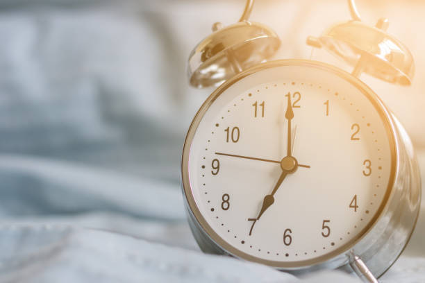istock Clock on the bed in the morning. 821685400
