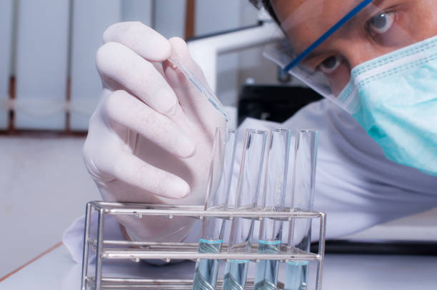 istock Scientist droping liquid to the sample tubes with microscope in laboratory room. Scientific research 821702080