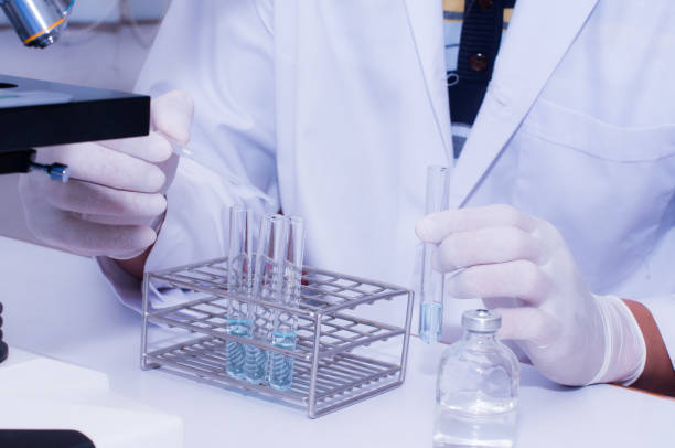 istock Scientist droping liquid to the sample tubes with microscope in laboratory room. Scientific research 821702084