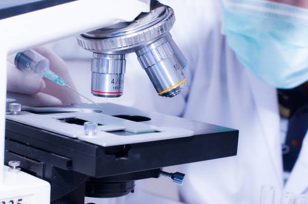istock Scientist droping liquid to the slide with microscope in laboratory room. Scientific research 821702106
