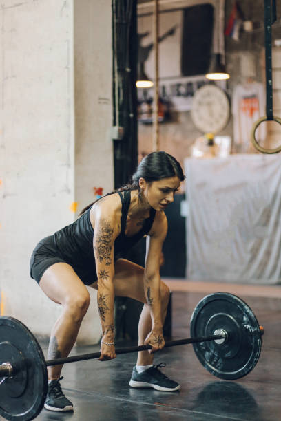 istock Young woman lifting weights on cross training 821702420