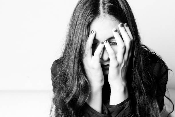 istock Sad brunette girl, hands on face, sitting in a couch. 821702554