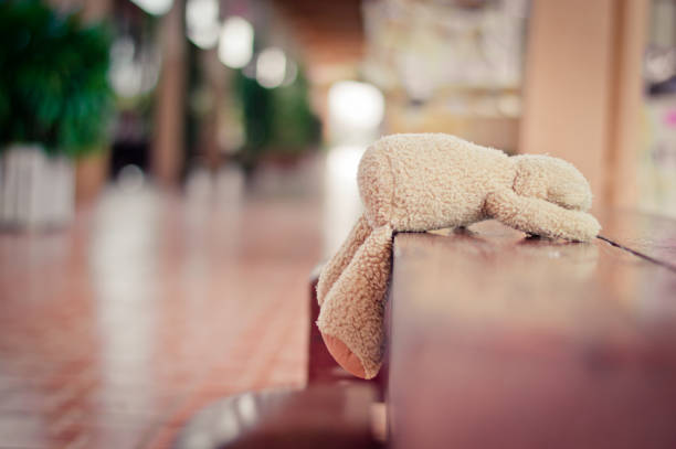 Little teddy bear tourist at city sit on his suitcase on curbside and look after the missed bus (copy space)