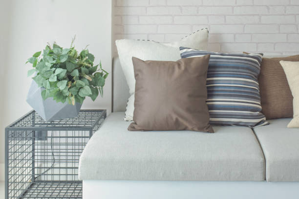 istock Plant pot on side table next to beige color sofa 821716462