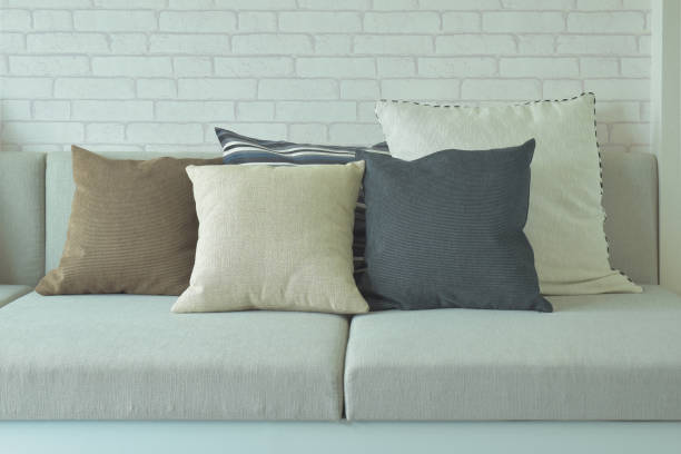 istock Pillows on beige cushion with white brick wall in background 821719698