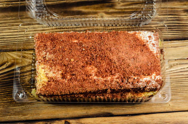 istock Biscuit cake in plastic container on wooden table. Top view 821720254
